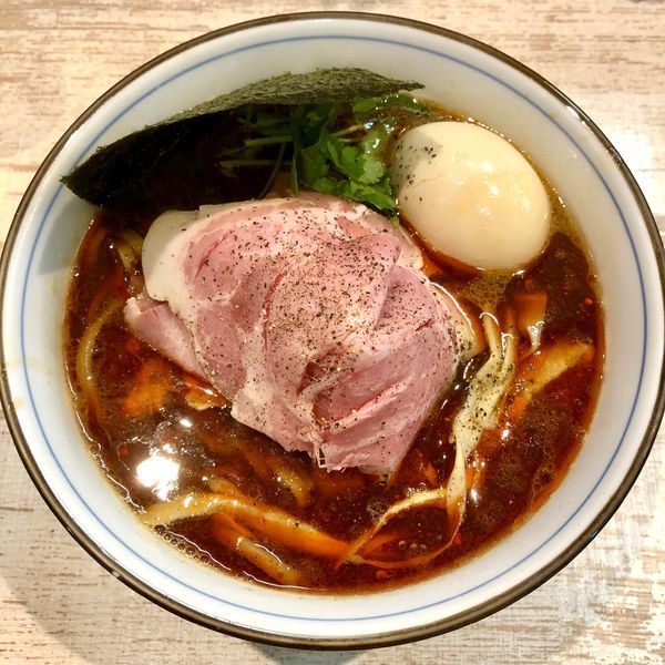 「【気まぐれ限定】辛い四つ葉ブラック (味玉付き) ￥900」@中華そば 四つ葉の写真