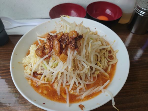 「辛ラーメン ニンニクアブラ 生卵 玉ねぎ」@ラーメン武丸の写真