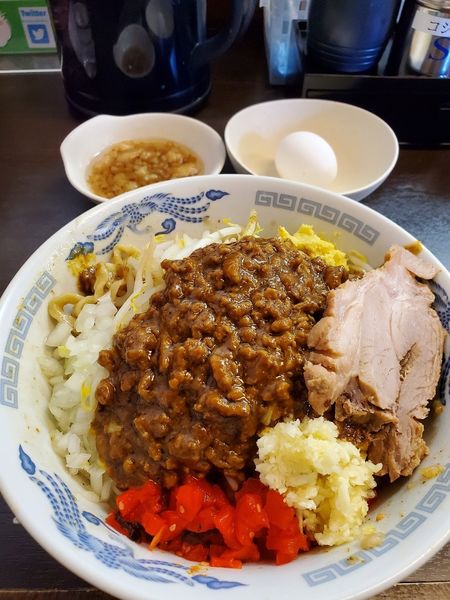 「スパイシーカレー油そば　にんにく　しょうが　アブラ　生玉子」@ラーメンどでん 大宮店の写真