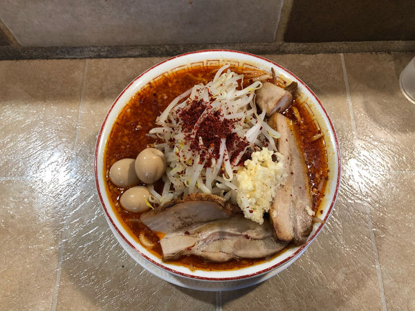 「辛マンモスラーメン、ニンニク、うずら」@泪橋 溝の口店の写真