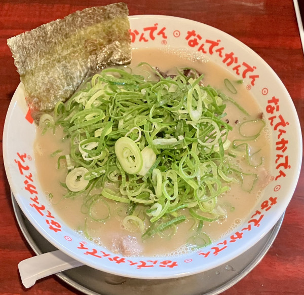 「豚骨ラーメン (ﾄｯﾋﾟﾝｸﾞ)青ねぎ (+替え玉)」@なんでんかんでん 西新宿店の写真